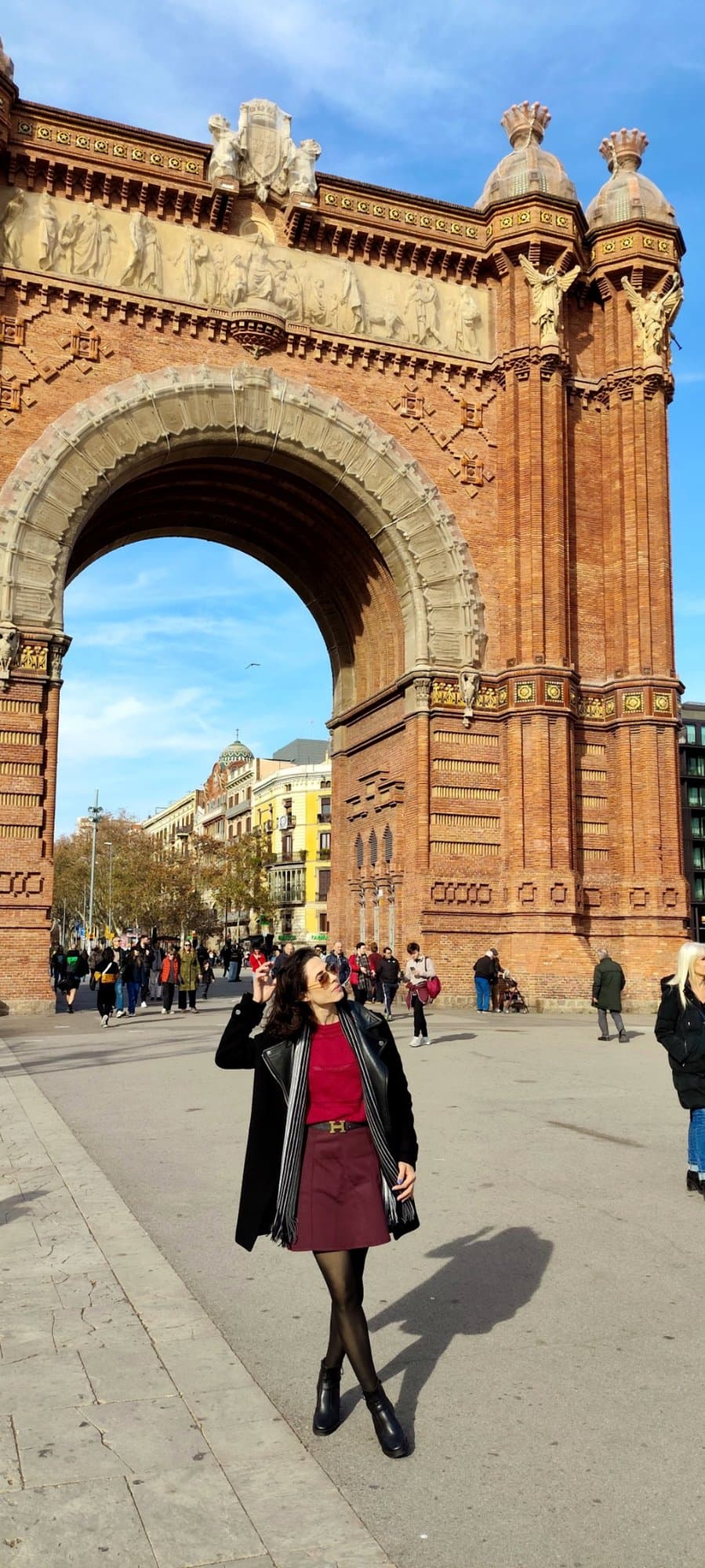 Camila frente al Arco de Triunfo de Barcelona en un día de cielo azul.