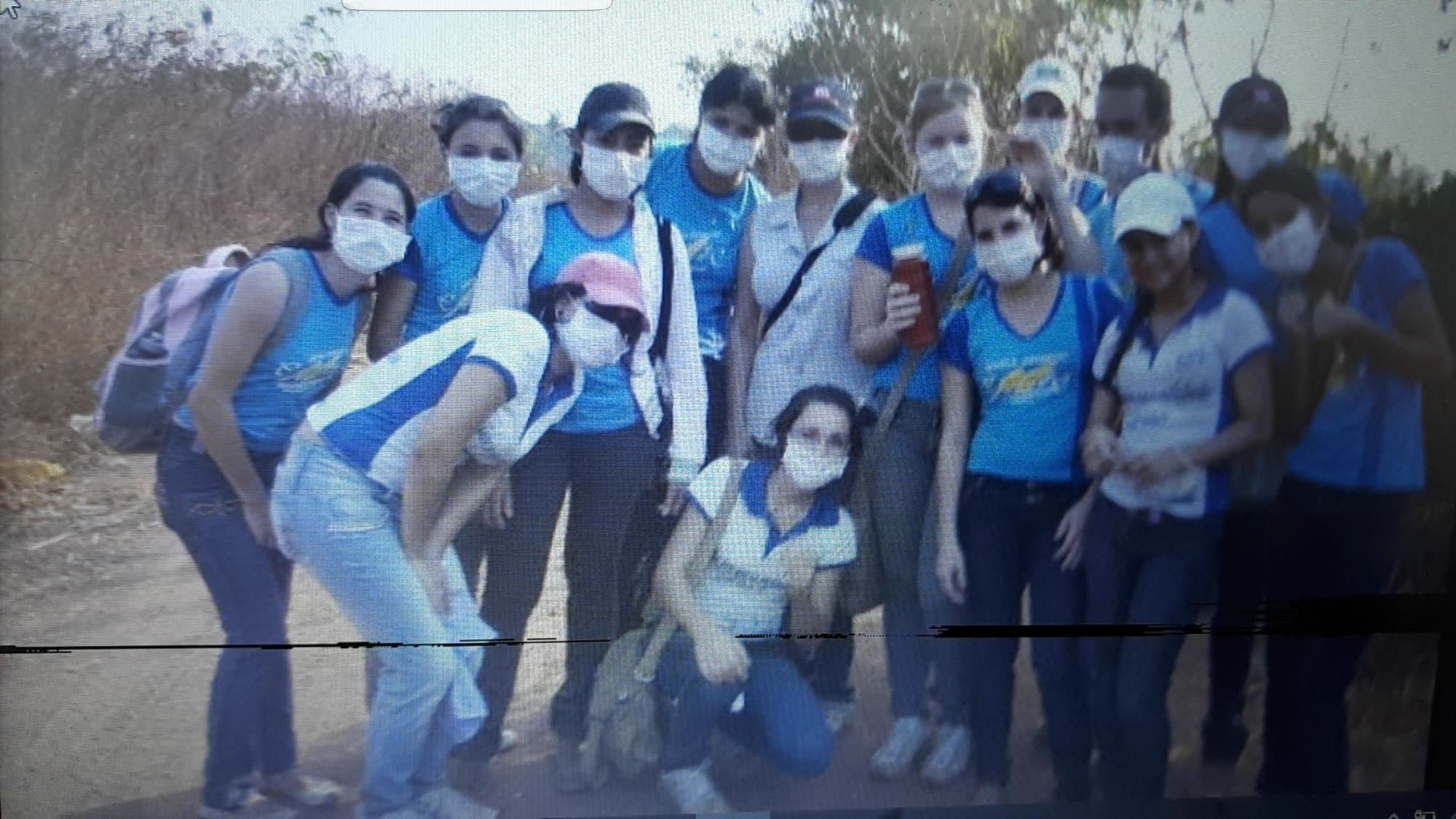 Grupo de estudiantes de secundaria con camiseta azul en un camino de tierra.