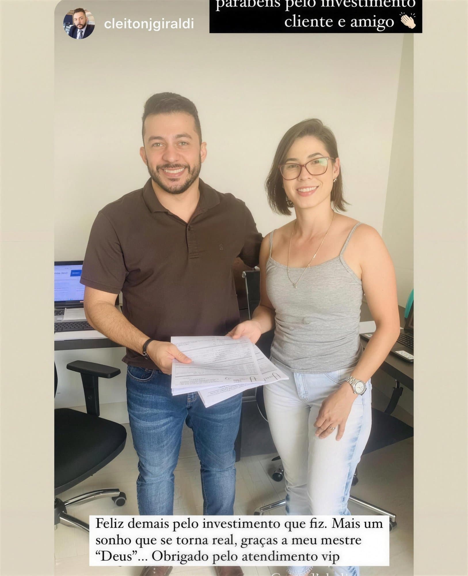 Camila, con gafas y camiseta de tirantes gris, sonríe junto a un hombre con polo marrón; juntos sostienen una pila de papeles en una oficina.